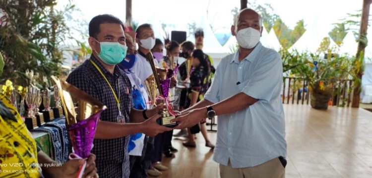 MENERIMA TROFI - Peserta dari perwakilan Kalteng saat menerima trofi pemenang kategori Anggrek Langka pada kegiatan Papua Orchid Show 2021. (Photo/ist)
